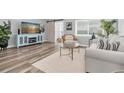 Cozy living room with wood-look floors, a stylish blue media cabinet, and a sliding barn door at 6511 10Th N St, St Petersburg, FL 33702