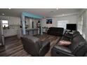 Modern living room with hardwood floors seamlessly connects to the open kitchen area, perfect for entertaining at 7684 Oakhurst Rd, Seminole, FL 33776