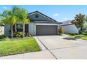 Single-story home with a two-car garage, landscaped yard, and a well-maintained lawn at 9839 Lemon Drop Loop, Sun City Center, FL 33573