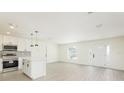 Bright and airy living room with hardwood floors seamlessly open to a modern kitchen area at 1008 Shangri La Dr, Seffner, FL 33584
