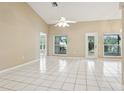Bright living room with neutral paint, tile flooring and a high ceiling with a ceiling fan at 10304 Rainbow Oaks Dr, Hudson, FL 34667