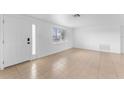 Bright living room featuring tile floors, white walls, and a front door at 1051 Pert Ln, Holiday, FL 34691