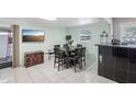 Spacious dining room featuring an adjacent bar area, tile flooring, and large windows at 109 Emerald Ln, Largo, FL 33771