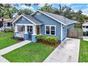 Inviting blue home featuring a well-maintained yard and a classic architectural style at 111 E Jean St, Tampa, FL 33604