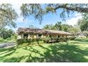 Charming single-story house with stone accents, lush lawn, and mature foliage under a bright sky at 11307 Sandpine Rd, Riverview, FL 33569