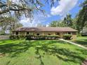 Charming ranch home featuring a stone facade and manicured front lawn at 11307 Sandpine Rd, Riverview, FL 33569