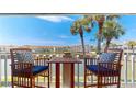Relaxing condo balcony with seating offers serene waterfront views under the palm trees at 12132 Capri S Cir, Treasure Island, FL 33706
