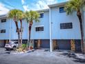 Two-story condos featuring private garages, stone accents, and lush tropical landscaping at 12132 Capri S Cir, Treasure Island, FL 33706