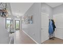 Inviting hallway with tiled floors, decorative mirror, and coat closet offers a warm welcome at 13301 Waterleaf Garden Cir, Riverview, FL 33579