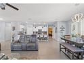 Open-concept living area featuring tiled floors, modern furniture, and seamless kitchen access at 13301 Waterleaf Garden Cir, Riverview, FL 33579