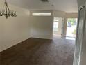 Spacious living room featuring neutral-colored walls, plush carpeting, and an abundance of natural light at 15733 Stable Run Dr, Spring Hill, FL 34610