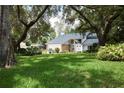 Home's exterior boasts a lush green lawn and mature trees, creating a tranquil and inviting atmosphere at 15917 Dover Cliffe Dr, Lutz, FL 33548