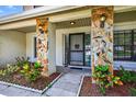 Inviting entryway with decorative stone columns, ambient lighting and neat landscaping at 15925 Marshfield Dr, Tampa, FL 33624