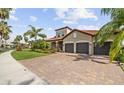 Attractive home with terracotta roof, three-car garage, and paver driveway offers ample parking at 165 Mobbly Bay Dr, Oldsmar, FL 34677