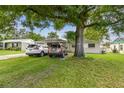 Exterior of home, shaded front yard, driveway with two cars at 1711 W Followthru Dr, Tampa, FL 33612