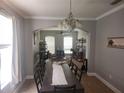 Elegant dining room featuring tile floors, a chandelier, and an arched entrance into a room with a ceiling fan at 1753 Open Field Loop, Brandon, FL 33510