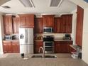 Well-equipped kitchen with stainless steel appliances, granite countertops, and rich brown cabinets, providing ample storage at 1753 Open Field Loop, Brandon, FL 33510
