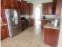 Spacious kitchen features tile floors, stainless steel appliances and wood cabinetry at 1753 Open Field Loop, Brandon, FL 33510