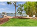 Beautiful backyard featuring a wooden deck, dining area, and access to the lake with mature trees for shade at 21906 Shamu Dr, Land O Lakes, FL 34639