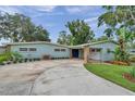 Inviting exterior of a blue home featuring a circular driveway and charming stone accents at 21906 Shamu Dr, Land O Lakes, FL 34639