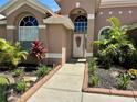 Well-maintained front yard with inviting walkway leading to the front door with decorative wreath at 28826 Windover St, Wesley Chapel, FL 33545