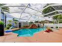Screened-in pool with a waterfall feature and beautifully landscaped surroundings at 28826 Windover St, Wesley Chapel, FL 33545