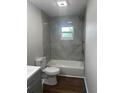 Modern bathroom featuring new tile tub surround, and wood-look flooring at 3505 Medulla Rd, Plant City, FL 33566