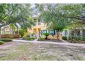 Inviting two-story house with a bright yellow facade, complemented by blue shutters and a meticulously maintained front lawn at 511 Winterside Dr, Apollo Beach, FL 33572