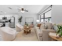 Bright living room featuring large windows, plush seating, a ceiling fan, and modern decor accents at 6370 Elmhurst Dr, Pinellas Park, FL 33782