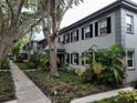 Exterior view of condo building with lush greenery and sidewalk at 6925-A Avenue Des Palais # 1A, South Pasadena, FL 33707