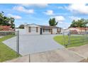 This single-story home is surrounded by a chain link fence and lush green grass at 7107 Limestone Ln, Tampa, FL 33619