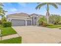 Attractive home features a three-car garage, tropical landscaping and an American flag at 7114 Bowspirit Pl, Apollo Beach, FL 33572
