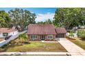 Charming single-story home with a well-maintained front yard, double door entry, and attached garage at 7206 Timber Ct, Tampa, FL 33625
