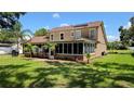 Beautiful home exterior featuring a screened-in patio and lush green lawn, perfect for outdoor living and entertaining at 7206 Timber Ct, Tampa, FL 33625
