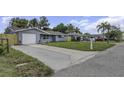 Single-story home with gray exterior, driveway, and a manicured front lawn at 7625 Marechal Ave, Port Richey, FL 34668