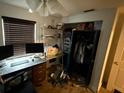 A cluttered room with shelving, a desk, and a closet, showcasing potential storage and workspace at 8606 N 9Th St, Tampa, FL 33604