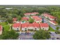 Aerial view of condo community with pool, lush trees, and ample parking space at 9481 Highland Oak Dr # 212, Tampa, FL 33647