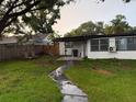 Backyard with green grass, trees, back patio, and wooden fence at 104 W Wildwood St, Tampa, FL 33613
