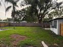 Large grassy backyard featuring mature trees and a wooden fence at 104 W Wildwood St, Tampa, FL 33613