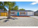Well-maintained home featuring a landscaped yard, bright blue door, and an attached garage at 11520 Meadow Dr, Port Richey, FL 34668