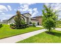 Attractive house with neatly trimmed shrubs, green lawn, and a spacious driveway at 12652 Shetland Walk Dr, Lithia, FL 33547
