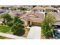 Aerial view of a single-story home in a residential neighborhood with manicured lawn and neutral color scheme at 15682 Stone House Dr, Brooksville, FL 34604