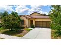 Inviting single-story home with manicured landscaping, neutral paint, and an attached two-car garage at 15682 Stone House Dr, Brooksville, FL 34604