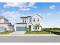 Charming two-story home featuring manicured landscaping, a paved driveway, and a teal garage door at 1583 Running Tide Pl, Sarasota, FL 34240