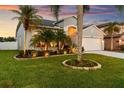A delightful one-story house showcases tropical foliage, manicured landscaping, and an attached two-car garage at 1631 Shady Oaks Dr, Oldsmar, FL 34677