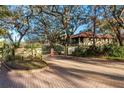 Gated community entrance with lush landscaping and mature trees at 1712 Hammock Pine Blvd # 1712, Clearwater, FL 33761