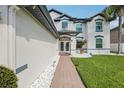 Inviting entryway featuring a brick walkway, manicured lawn, and double glass front doors at 1802 Regal Mist Loop, Trinity, FL 34655