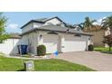 A charming house with a three car garage, an American flag, and a well maintained lawn at 1802 Regal Mist Loop, Trinity, FL 34655
