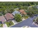 An aerial view showcasing the house, neighborhood, landscaping, and surrounding greenery at 1830 Springwood N Cir, Clearwater, FL 33763