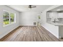 Bright living room featuring natural light, modern ceiling fan, and newly installed wood-look floors at 1843 Berg Rd, Holiday, FL 34690